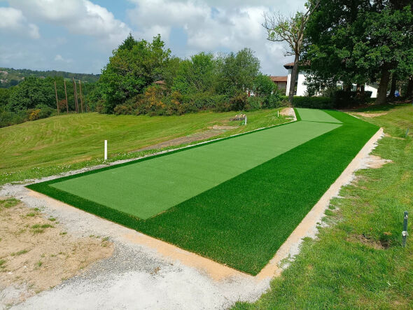 Toronto Outdoor tee line consisting of one continuous green synthetic grass strip surrounded by trees